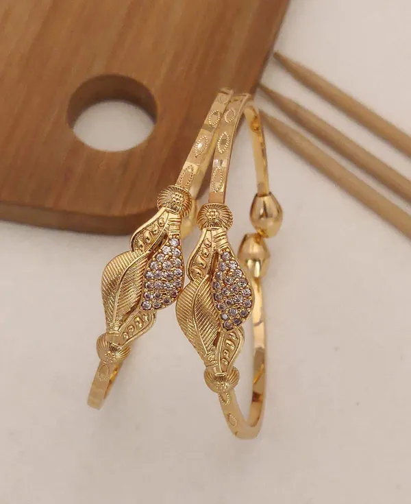 https://cdn-image.blitzshopdeck.in/ShopdeckCatalogue/tr:f-webp,w-600,fo-auto/63d376eebab1840012c58c11/media/Delicate_and_elegant_gold_bangles_with_intricate_leaf_design_and_sparkling_white_stones__Perfect_for_any_occasion__CTT78NGB6Q_2024-05-21_1.jpeg