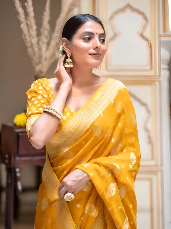 https://cdn-image.blitzshopdeck.in/ShopdeckCatalogue/tr:f-webp,w-600,fo-auto/65e1b534eddd14767aed70e6/media/Yellow_Banarasi_Silk_Weaved_Georgette_Saree_S5XAUMI5S5_2024-05-03_1.jpeg__Aura Silk